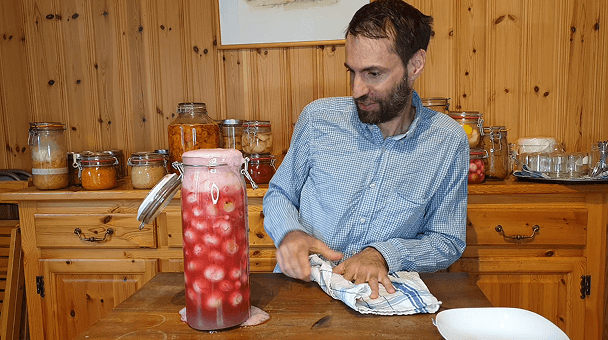Laurent, fondateur de Fermentierra, dans son atelier avec des bocaux de lactofermentation